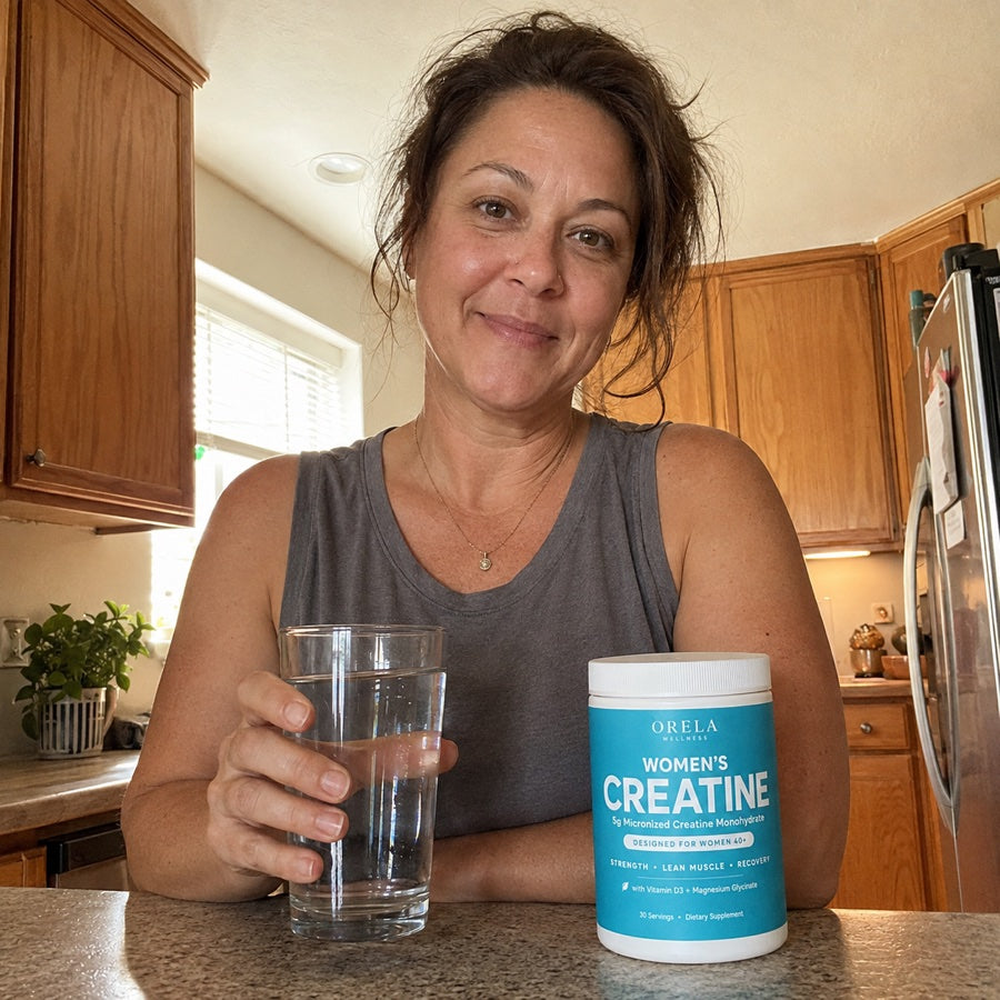 Woman with a glass of water beside Orela Women’s Creatine