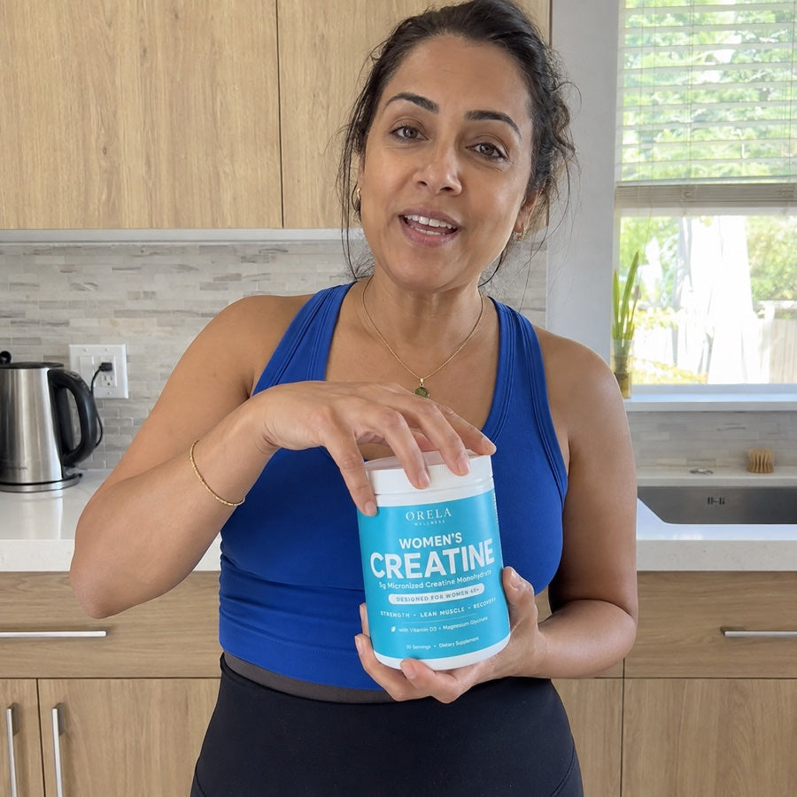 Woman holding Orela Women’s Creatine in her kitchen