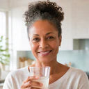 Woman preparing a daily wellness drink in her kitchen